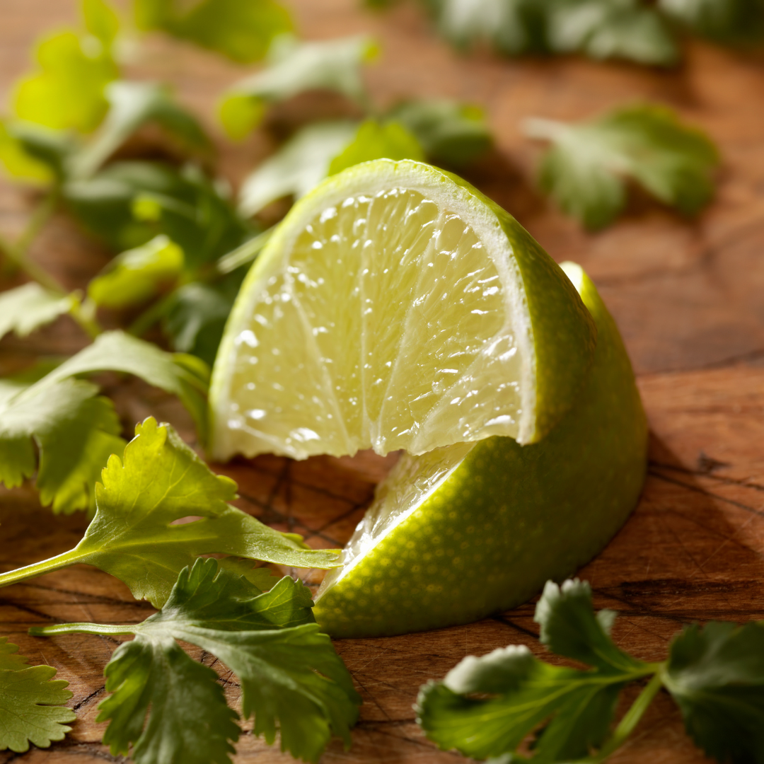 cut lime wedges and sprinkled cilantro on a wooden board